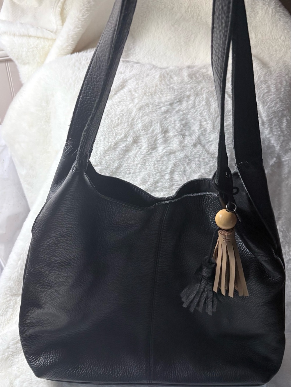 The Sak Black Leather Shoulder Bag with Tan Tassel Charm